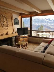 sala de estar con sofá y TV en Vue Mont Blanc et toute la chaîne, en Combloux
