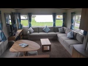 a living room with a couch and a table at Holiday Escapes in Selsey