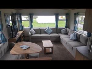 uma sala de estar com um sofá e uma mesa em Holiday Escapes em Selsey