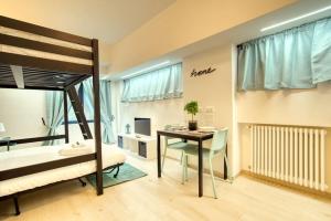 1 dormitorio con litera, mesa y escritorio en Apartment Suzzani 273 - Interno A2, en Milán