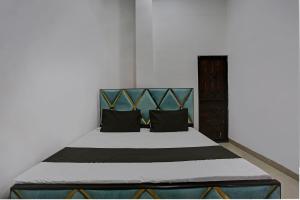 um quarto com uma cama grande e almofadas pretas em SPOT ON Shree Sarveshwar Party Lawn And Hotel em Kanpur