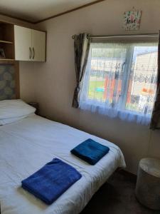 sypialnia z 2 niebieskimi ręcznikami na łóżku w obiekcie Holiday Escapes w mieście Selsey