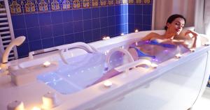 a woman sitting in a bath tub with candles at El Mouradi Palace in Port El Kantaoui