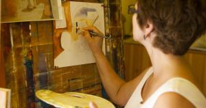 a woman painting a picture on a wall at El Mouradi Palace in Port El Kantaoui