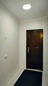 een hal met een bruine deur en een zwart tapijt bij Võhma industriaal pesa 