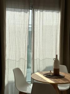 einen Tisch und Stühle vor einem Fenster in der Unterkunft ART HOMES LAVADERO in Valencia