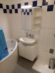 een witte badkamer met een wastafel en een bad bij Apartment near Downtown in Wenen