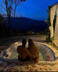 un hombre y una mujer sentados en una fuente por la noche en Cabaña Aguadulce, en San Rafael