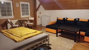 1 dormitorio con cama, sofá y mesa en MotoHostel Wolter - hostel Copa en Všeň