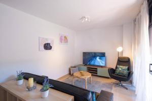 a living room with a couch and a tv at Phoebe Apartment - city centre of Santa Cruz in Santa Cruz de la Palma