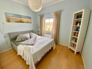 a bedroom with a bed and a book shelf at discovAIR Graal-Müritz -Villa Victoria- Strandnah mit Netflix in Graal-Müritz