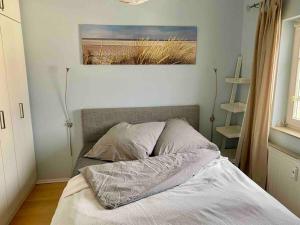 a bed in a bedroom with a picture on the wall at discovAIR Graal-Müritz -Villa Victoria- Strandnah mit Netflix in Graal-Müritz