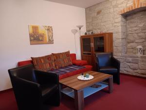 a living room with a couch and a table and chairs at Gästehaus Am Hasenturm in Bernburg