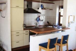 a kitchen with a table and two chairs in it at Deetje in Borkum