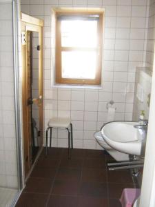 a bathroom with a sink and a toilet and a window at Deetje in Borkum