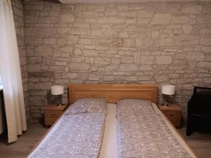 a bedroom with a bed and a stone wall at Gästehaus Am Hasenturm in Bernburg