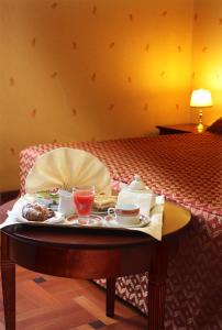 a tray of food on a table on a bed at Hotel Excelsior in Cosenza