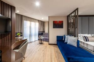 a living room with a blue couch and a bedroom at Aprilis Deluxe Hotel in Istanbul +76 photos