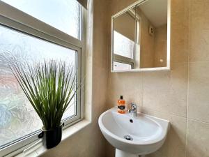a bathroom with a sink and a window at Large 4 Bedroom Home, Close To Leeds City Centre in Kirkstall