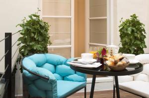 a blue chair and a table with a bowl of food at Hotel Dupond-Smith in Paris
