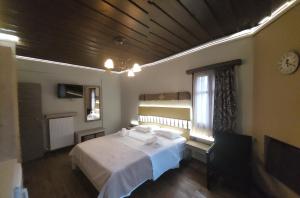 a bedroom with a white bed and a window at Matzato in Monodendri