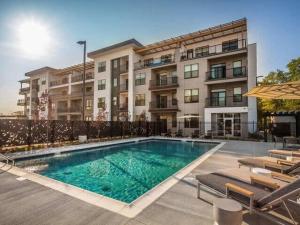 a swimming pool in front of a apartment building at Cozysuites Spacious 2BR next to Whole Foods in Indianapolis