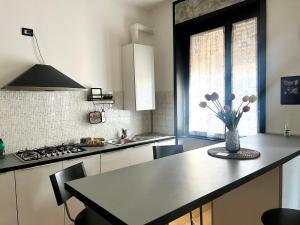 a kitchen with a table with a vase of flowers on it at Appartamento Dante in Seregno