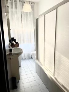 a white bathroom with a sink and a window at Appartamento Dante in Seregno