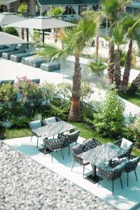 a patio with tables and chairs and palm trees at Comfort Suites in Golem