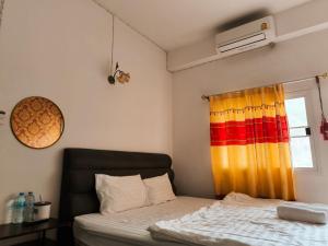 a bedroom with a bed and a window at SB Betong ห้องพักรายวัน in Betong