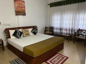 a bedroom with a large bed and a window at Why Not Palace in Anuradhapura