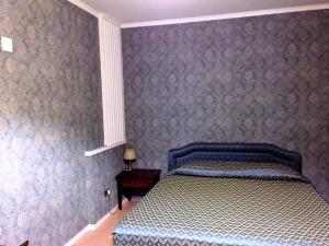 a bedroom with a bed with a blue and white comforter at Hotel Excelsior in Cosenza