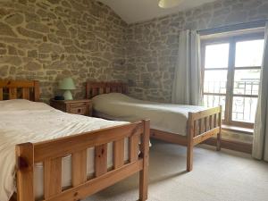 1 dormitorio con 2 camas y ventana en Maison Brandon, en La Chapelle-Montbrandeix