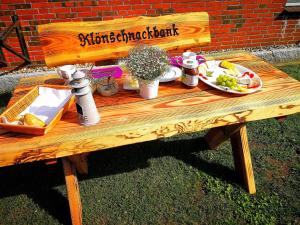 a wooden bench with a table with food on it at Gästehaus Nord-West 1700 - Einzelzimmer "Düne" in Steenfeld
