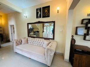 Maples Holiday Resort في نوارا إليا: غرفة معيشة مع أريكة بيضاء ومرآة