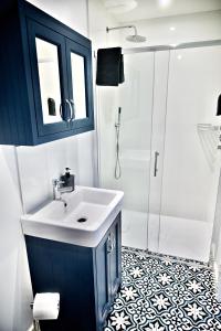 a bathroom with a sink and a shower at Criccieth- STUDIO GLAN ERIN BACH in Criccieth