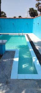 a blue swimming pool with a bench in it at Palm Path Resort in Jaffna