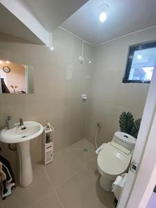 Baño blanco con lavabo y aseo en San Pablo Tropical Transient House, en San Pablo