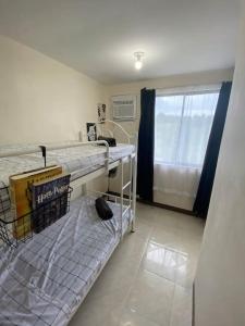 ein Krankenhauszimmer mit 2 Etagenbetten und einem Fenster in der Unterkunft San Pablo Tropical Transient House in San Pablo City
