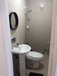 La salle de bains blanche est pourvue de toilettes et d'un lavabo. dans l'établissement San Pablo Tropical Transient House, à San Pablo