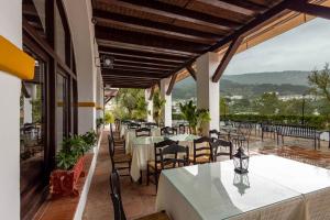 a restaurant with tables and chairs on a patio at Hotel Tugasa Las Truchas in El Bosque