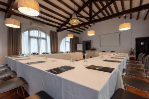 una sala de reuniones con una larga mesa blanca y sillas en Hotel Tugasa Las Truchas, en El Bosque