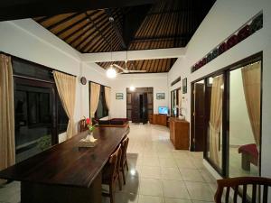 - une salle à manger avec une table et des chaises en bois dans l'établissement Sari Kembang villa ubud, à Ubud