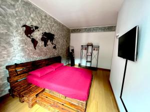 a bedroom with a large bed with a pink blanket at Appartamento Dante in Seregno