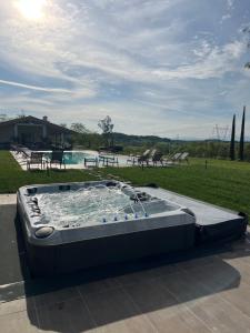 a large hot tub sitting on top of a patio at Agriturismo Colle Dei Pivi in Ponti Sul Mincio