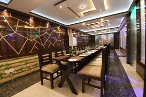 Āsansol的住宿－Hotel Jyoti International，长长的用餐室配有长桌子和椅子