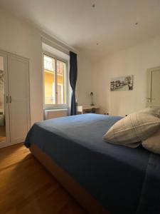 - une chambre avec un grand lit bleu et une fenêtre dans l'établissement La Stamperia, à Rome