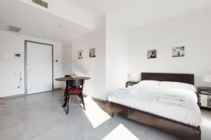 - une chambre avec un lit et une table avec une chaise dans l'établissement Udine M2 - Bright and cozy studio, à Milan