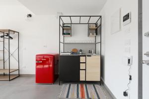 uma cozinha com um frigorífico vermelho num quarto em Udine M2 - Bright and cozy studio em Milão