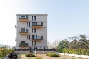 - un bâtiment blanc avec des balcons sur le côté dans l'établissement Udine M2 - Bright and cozy studio, à Milan